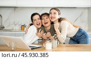 Three happy middle-aged woman expressing joy for winning in the kitchen. Стоковое фото, фотограф Яков Филимонов / Фотобанк Лори