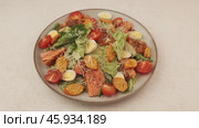 Caesar salad with trout (salmon), cherry tomatoes, croutons, parmesan cheese, quail eggs and romaine lettuce. A woman adds cheese to a plate. Traditional American dish. Close-up, selective focus. Стоковое видео, видеограф Наталья Любина / Фотобанк Лори