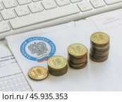 Растущий график из монет на фоне письма из налоговой службы (2024 год). Редакционное фото, фотограф Татьяна Т / Фотобанк Лори