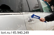 A man who thoroughly cleans his car of ice in winter using a special scraper. Advertising of car cosmetics, winter accessories and car repair services. Winter car care. Removing ice from a car. Banner. Стоковое видео, видеограф Евгений Демидюк / Фотобанк Лори