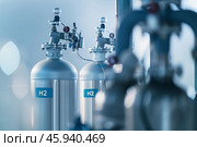 A large silver tanks labeled with H2, indicating hydrogen storage, in a modern industrial facility. Bright bokeh lights create a futuristic atmosphere. Стоковое AI-изображение, AI-художник Михаил Строгалев / Фотобанк Лори