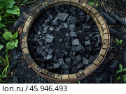 Wooden container full of charcoal briquettes standing on the ground. Стоковое AI-изображение, AI-художник Иван Рябоконь / Фотобанк Лори