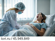 A pregnant woman in a hospital bed in the maternity ward. The woman is in labor and screaming in pain. Pregnancy and childbirth. Стоковое AI-изображение, AI-художник Photojuli / Фотобанк Лори