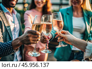 Glasses of pink sparkling wine in the hands of people. People are relaxing on the outdoor veranda. The concept of recreation, corporate event, party or celebration. Стоковое AI-изображение, AI-художник Photojuli / Фотобанк Лори