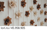 Christmas Paper Flowers Decoration. Handmade Christmas Nordic Decor on a Light Background against the Wall. Boho, Scandinavian Style Design. DIY. Minimal Ornament. Structural Origami. Zero Waste. Стоковое AI-видео, аниматор Марина Демидюк / Фотобанк Лори