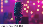 Microphone on the stage in concert hall or conference room. Close-up of a microphone in focus with a blurred pink purple bokeh background. Public speaking and live events concept. Neon light. Audience. Стоковое AI-видео, аниматор Марина Демидюк / Фотобанк Лори