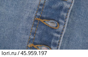 Fastener loops in blue jeans. the rotation of the fabric of blue jeans in close up details. denim texture, abstract background. clothing concept and tailoring. Стоковое видео, видеограф ЛУНИНА ВЕРОНИКА / Фотобанк Лори