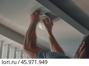 Ceiling smoke detector installation for home safety and fire prevention. Стоковое AI-изображение, AI-художник Zakharova Natasha / Фотобанк Лори