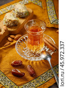 Azerbaijani black tea in armudu tea glass. Atmosphere of Baku and Eastern traditions. Oriental cuisine. Cozy atmosphere in the caucasus cafe. Стоковое фото, фотограф Андрис Салминьш / Фотобанк Лори