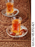 Azerbaijani black tea in armudu tea glass. Atmosphere of Baku and Eastern traditions. Oriental cuisine. Cozy atmosphere in the caucasus cafe. Стоковое фото, фотограф Андрис Салминьш / Фотобанк Лори