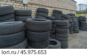 Storage of discarded old car tires outdoors, showcasing a pile of used tires ready for recycling. Highlighting environmental concerns and rubber waste management. Стоковое фото, фотограф Ivan Murauyou / Фотобанк Лори