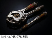 Mechanic tool with gears and interchangeable heads lying on reflective surface. Стоковое AI-изображение, AI-художник Иван Рябоконь / Фотобанк Лори