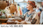 Woman choosing handmade wicker bag at outdoor craft market. Стоковое AI-изображение, AI-художник Юрий Поздников / Фотобанк Лори