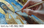 Artist painting religious icon with gold leaf and blue pigment. Стоковое AI-видео, аниматор Юрий Поздников / Фотобанк Лори