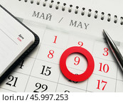 Планы на майские праздники. Календарь с отмеченным 9 мая - Днем Победы, блокнот и ручка. Стоковое фото, фотограф Ольга Дерябина / Фотобанк Лори