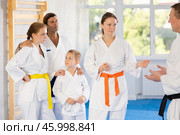 After completing family session and karate training, parents talk with male coach. Стоковое фото, фотограф Яков Филимонов / Фотобанк Лори