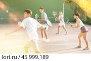 Guy hits the ball with a racket while playing frontenis on outdoor court. Стоковое фото, фотограф Яков Филимонов / Фотобанк Лори