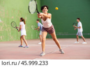 Woman playing frontenis with partners at sunny day, healthy lifestyle concept. Стоковое фото, фотограф Яков Филимонов / Фотобанк Лори