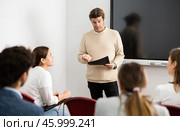Confident male leader, trainer near interactive board talking to group of people, brainstorming, discussing ideas in auditory. Стоковое фото, фотограф Яков Филимонов / Фотобанк Лори