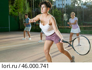 Woman playing frontenis with partners at sunny day, healthy lifestyle concept. Стоковое фото, фотограф Яков Филимонов / Фотобанк Лори