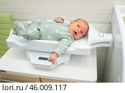 Младенца взвешивают на детских весах. Ребенку 1 месяц (30 дней) Стоковое фото, фотограф Яна Проничева / Фотобанк Лори