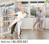 Positive duet of gymnasts rehearsing performance with support, mature modern ballet dancers in pair during group training session in ballet hall. Стоковое фото, фотограф Яков Филимонов / Фотобанк Лори