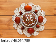 Easter composition with homemade tradition Easter cake on lace handmade napkin and painted red Easter eggs on wooden table. On Easter cake russian letters ХВ mean Christ is Risen. Flat lay, close-up. Стоковое фото, фотограф Виктория Катьянова / Фотобанк Лори