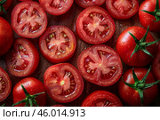 Fresh, juicy red tomatoes sliced and arranged with vibrant textures. A perfect top view for food photography, cooking, and organic produce themes. Стоковое AI-изображение, AI-художник Александра Троицкая / Фотобанк Лори