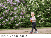 A beautiful chubby 2-year-old child in the park with a colorful Pop-it game. An anti-stress remedy. A pop It toy in children's hands. Стоковое фото, фотограф Photojuli / Фотобанк Лори