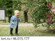 Portrait of a 1-year-old little boy outdoors. A happy child walks in the spring park. Happy childhood and fatherhood. Стоковое фото, фотограф Photojuli / Фотобанк Лори