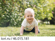 Portrait of a 1-year-old little boy outdoors. A happy child walks in the spring park. Happy childhood and fatherhood. Стоковое фото, фотограф Photojuli / Фотобанк Лори