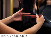 Hands of hairstylist combing and cutting long hair of brunette woman in barber shop, close-up. Hairdresser making fashionable hairstyle. Customer service at hair salon, haircare. Copy ad text space. Стоковое фото, фотограф Aleksandr Golubev / Фотобанк Лори