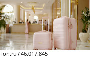 Travel bags in modern hotel lobby with blurred receptionists. Стоковое AI-изображение, AI-художник Анастасия Золотницкая / Фотобанк Лори