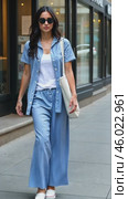 Stylish Woman Walking on City Street in Casual Blue Striped Outfit With White Accessories During Daytime Outing. Стоковое AI-видео, аниматор Sergey Grishin / Фотобанк Лори