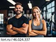 Two fitness trainers smiling with crossed arms in the gym. Стоковое AI-изображение, AI-художник Иван Рябоконь / Фотобанк Лори