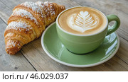 Green ceramic cup of frothy cappuccino coffee with croissants on rustic wood background. Hot latte with art milk foam and freshly-baked Brioche on cafe table. Breakfast or coffee break. Morning ritual. Стоковое AI-видео, аниматор Марина Демидюк / Фотобанк Лори