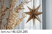 Christmas Paper Star and Ball Decoration. Handmade Christmas Nordic Decor on a Light Background against the Wall. Boho, Scandinavian Style Design. DIY. Minimal Ornament. Structural Origami. Zero Waste. Стоковое AI-видео, аниматор Марина Демидюк / Фотобанк Лори