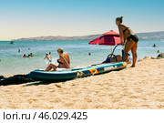 A young woman on the seashore is preparing to swim on a supboard (2024 год). Редакционное фото, фотограф Алексей Сорокин / Фотобанк Лори
