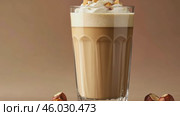 Mockup. Hot hazelnut coffee on a pale beige background. Space for text. Spice Latte or cappuccino. A rich and creamy hazelnut latte with a crumb of crushed nuts, served in a clear glass. Стоковое AI-видео, аниматор Марина Демидюк / Фотобанк Лори