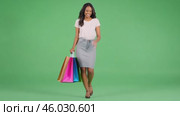 Cheerful woman shopper isolated on a Green Screen. Young girl in casual clothes walking with shopping bags on a green background. Sale day. Pretty happy female buyer having fun on Chroma Key Backdrop. Стоковое AI-видео, аниматор Марина Демидюк / Фотобанк Лори