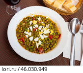 Guisantes a la Murciana - Peas Murcia Style. Juicy peas sauteed with cured ham served with boiled egg on plate, popular Spanish. Стоковое фото, фотограф Яков Филимонов / Фотобанк Лори