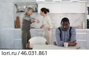 Angry middle-aged man sitting at table while two female family members disputing with each other in the back. Стоковое видео, видеограф Яков Филимонов / Фотобанк Лори