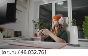Player fully engaged with controller in hand, immersed in virtual world. Headset enhances communication during multiplayer gaming, while their concentration reflects intensity of session. Стоковое видео, видеограф Енваев Андрей / Фотобанк Лори