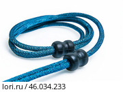 Blue paracord bracelet with black plastic beads lying on white background. Стоковое AI-изображение, AI-художник Иван Рябоконь / Фотобанк Лори