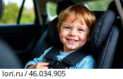 Protection in the car. Caucasian child is sitting and fastening with security belt in safety car seat. Стоковое AI-изображение, AI-художник Ирина Старикова / Фотобанк Лори