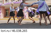 Female graduates joyfully dancing barefoot in the schoolyard, celebrating their graduation with sashes. Стоковое фото, фотограф Mikhail Davidovich / Фотобанк Лори