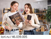 Two girls in store while shopping, choose sweets and chat sweetly. Стоковое фото, фотограф Яков Филимонов / Фотобанк Лори