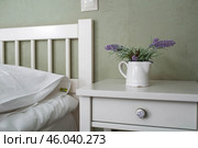 A bed with white sheets and a vintage Provence-style bedside table in a hotel room or a home bedroom. Space for the text. Enjoying the morning concept. Стоковое фото, фотограф Photojuli / Фотобанк Лори