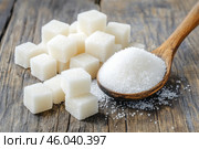 Sugar pile in a metal spoon on a wood surface. White granulated sugar and cubes. Natural seasoning. Refined sugar poured on wooden rustic table. Sugary sand. Cooking, cosmetology, spa services concept. Стоковое AI-изображение, AI-художник Марина Демидюк / Фотобанк Лори