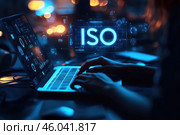 Футуристическое изображение: человек работает с голографическим экраном ноутбука, на котором доминируют буквы ISO. Стоковое AI-изображение, AI-художник Ярославский Максим / Фотобанк Лори